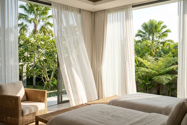 Motorised smart curtains opening in a bright Bali villa bedroom